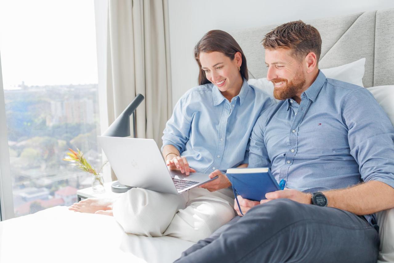 Meriton Suites Zetland Sydney Zewnętrze zdjęcie A couple using a laptop